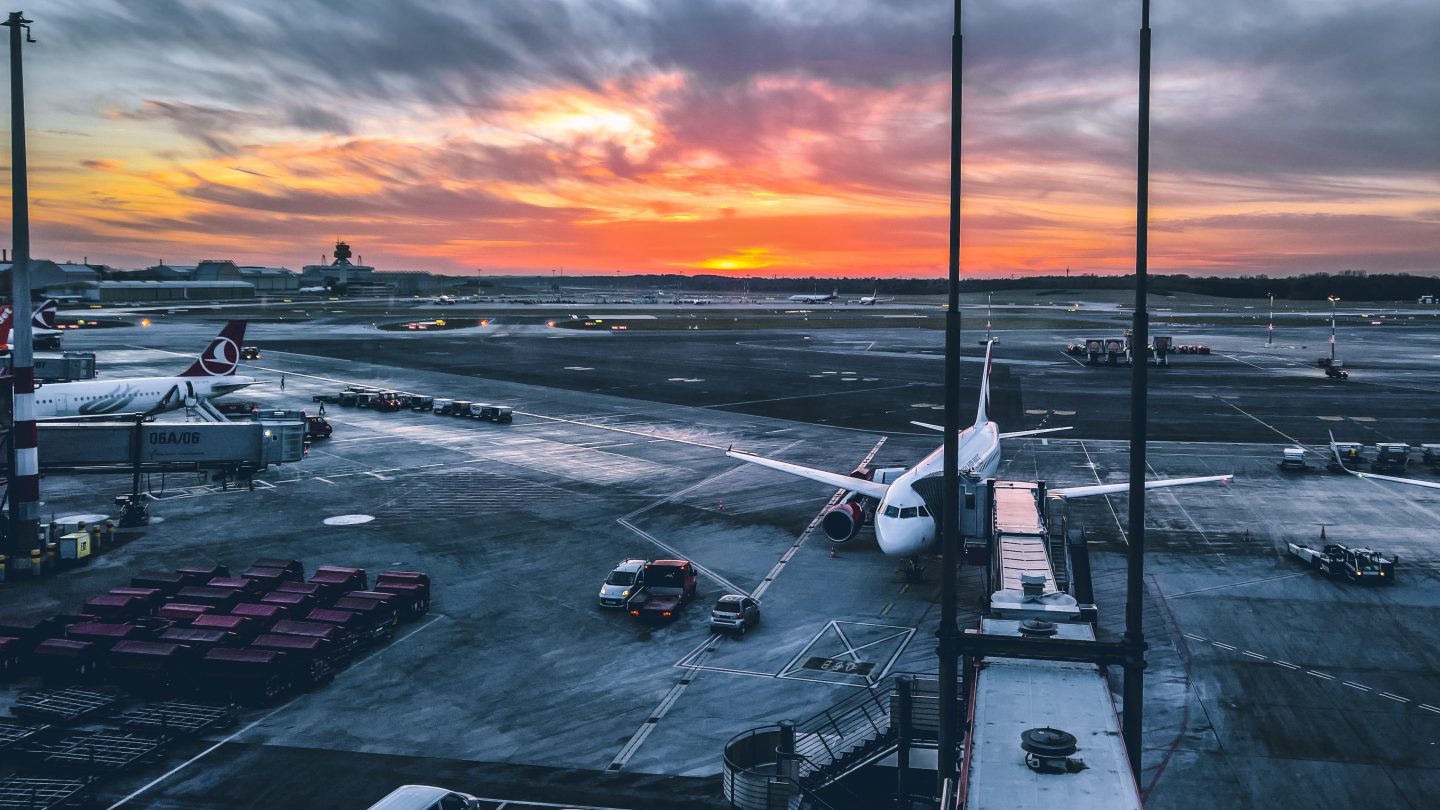 Plane sat on a runway as sun sets